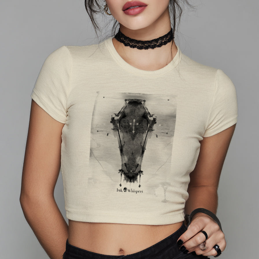 Woman wearing a beige t-shirt with a graphic design on a plain background