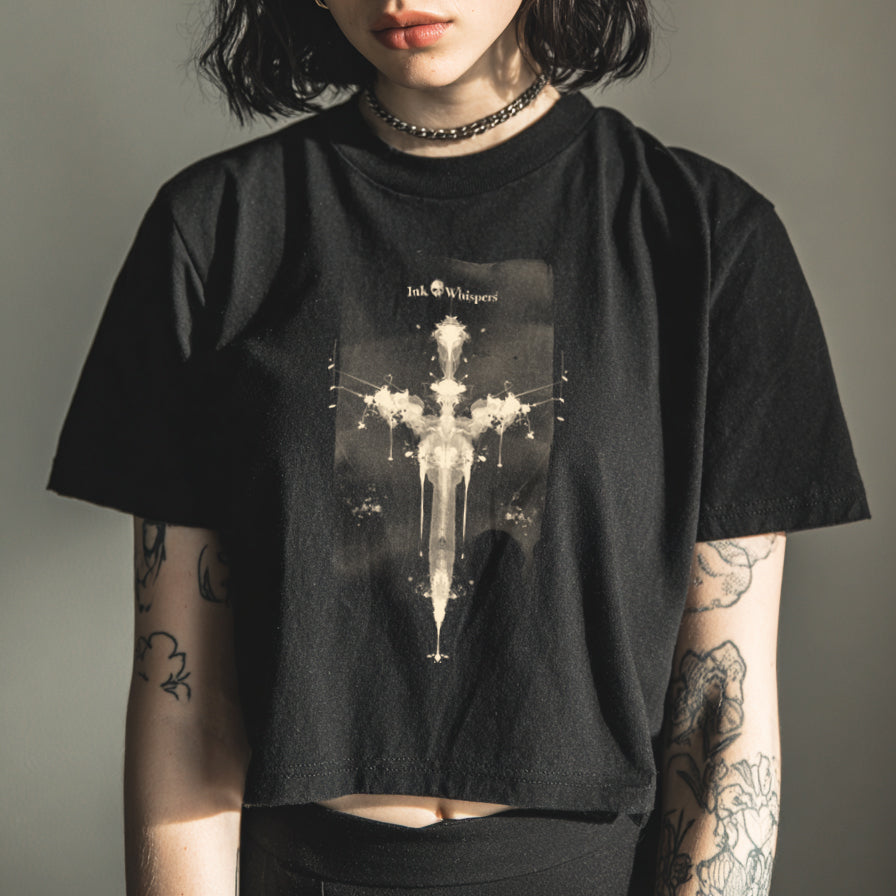 Person wearing a black t-shirt with a graphic design against a plain background