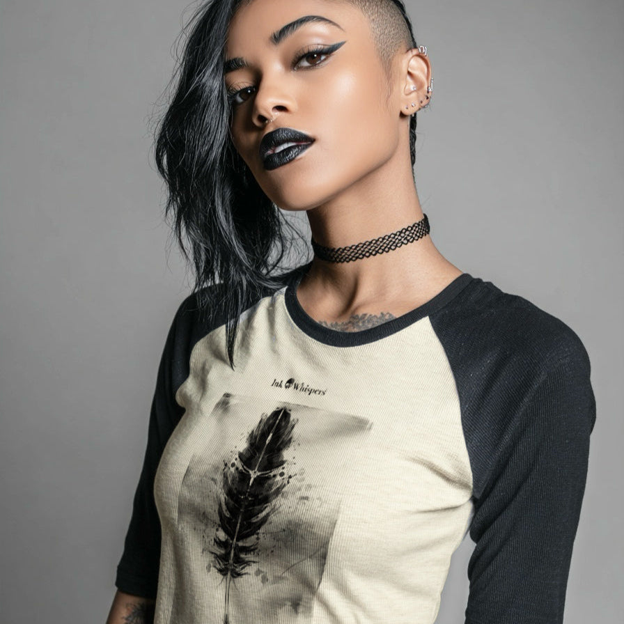 Person wearing a black and beige baseball shirt with a feather design on a gray background