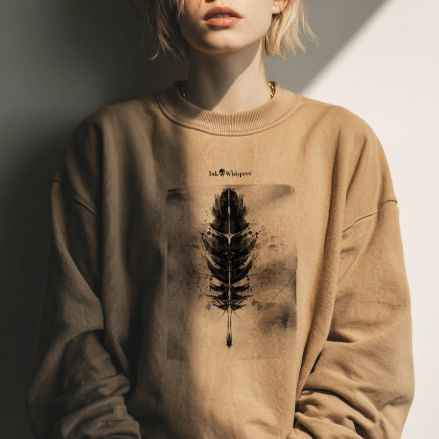 Woman wearing a beige sweatshirt with a graphic design against a neutral background