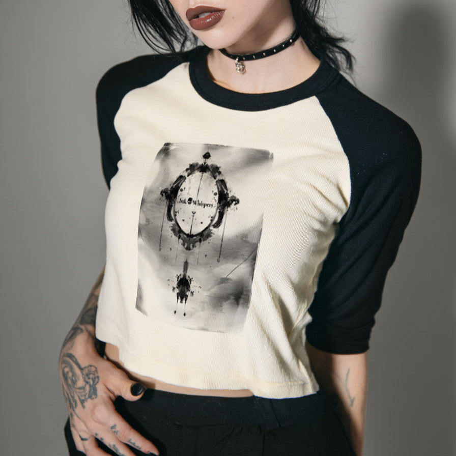 Woman wearing a black and white baseball shirt with a graphic design on a gray background