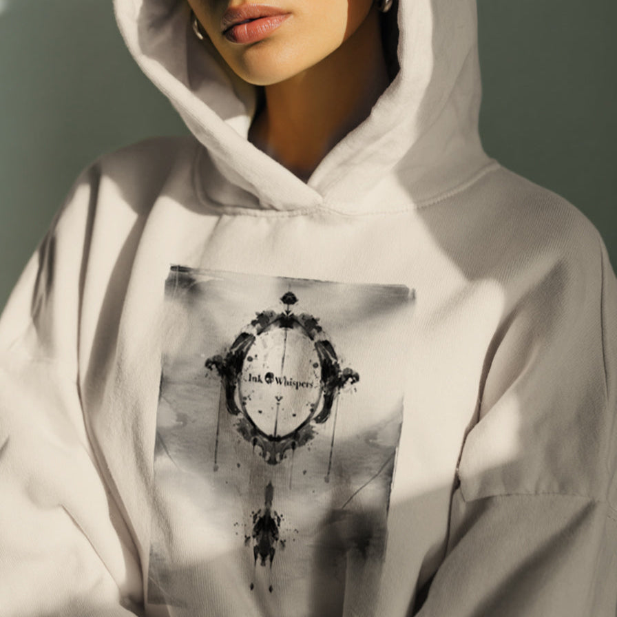 Person wearing a light gray hoodie with a graphic design on a neutral background