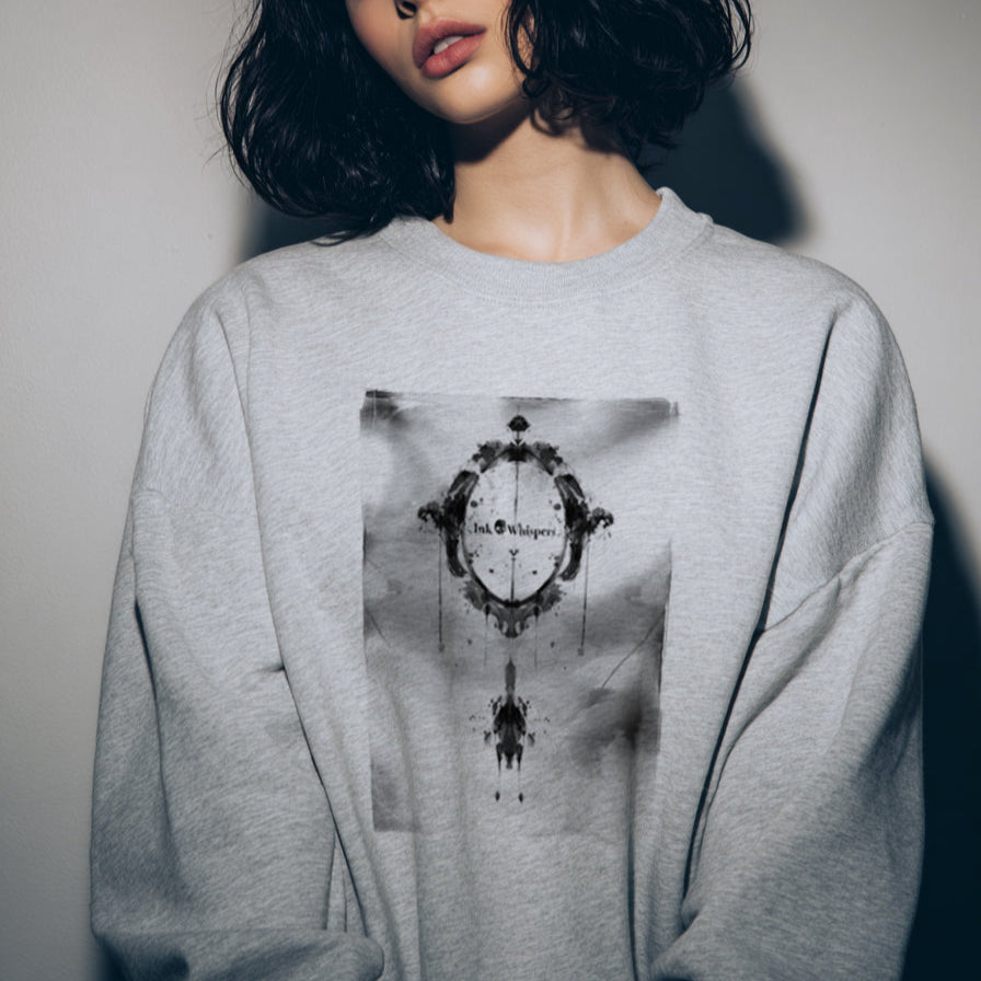 Person wearing a gray sweatshirt with a graphic design against a plain background