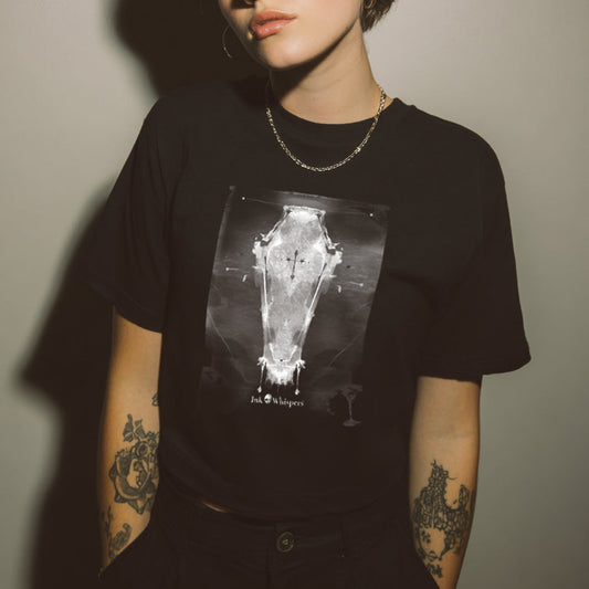 Person wearing a black t-shirt with a graphic design against a plain background