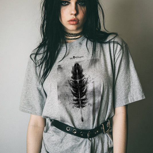 Person wearing a gray t-shirt with a feather design against a plain background